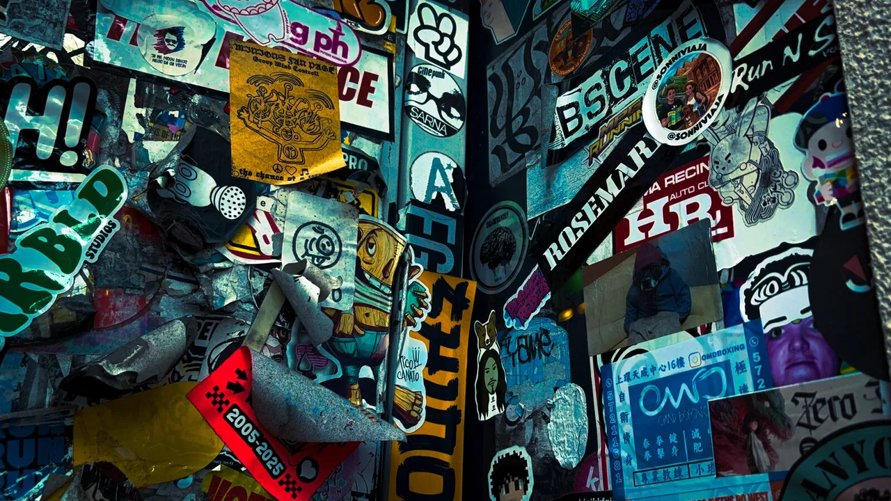 A corner layered with peeling stickers of every colour, logos, faces and slogans on top of one another.