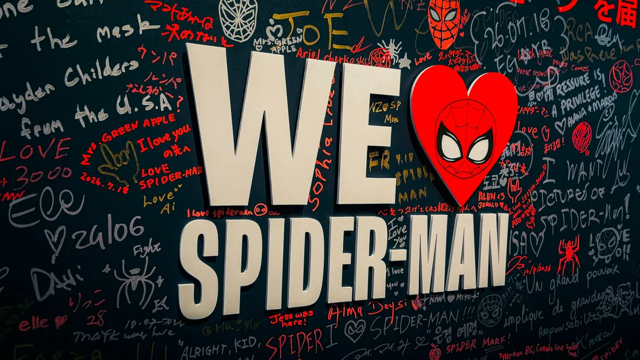 A black wall covered in handwritten messages from fans, around raised letters reading We ♥ Spider-Man.